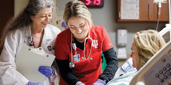 Nursing professor with a student working on a patient